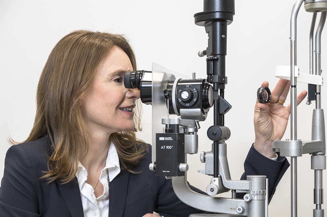 Retina specialist performing slit lamp eye examination during urgent retinal evaluation to assess the retina and vitreous for retinal tears or detachment.